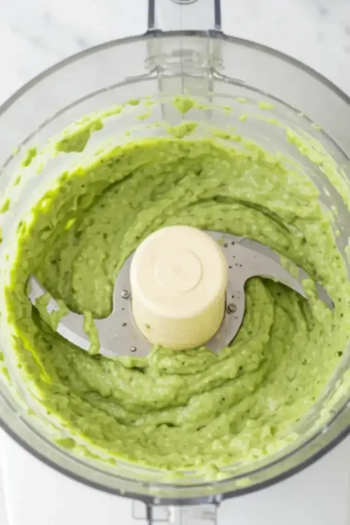 Creamy avocado sauce blended in a food processor for healthy zucchini noodles