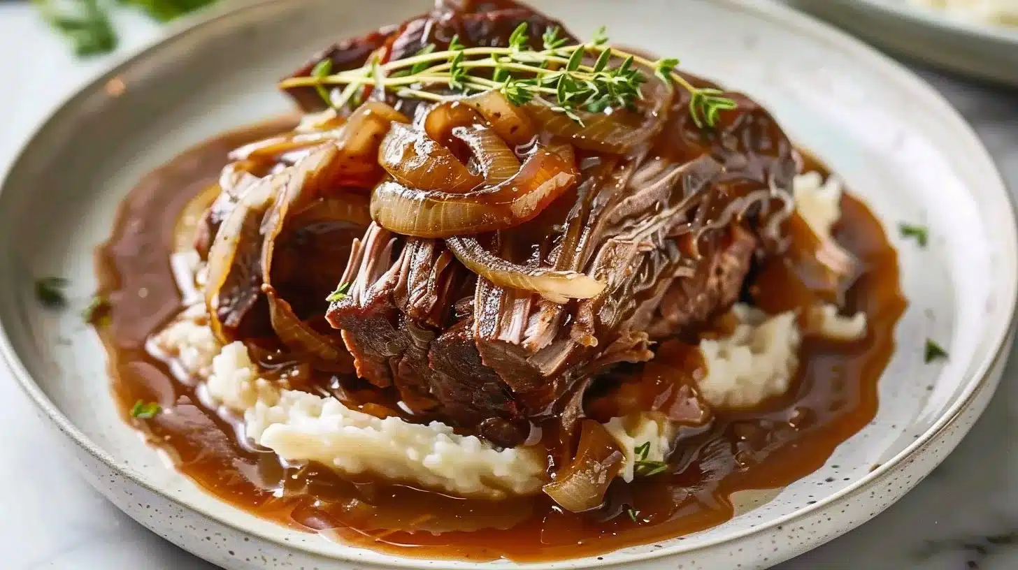 Savory slow cooker roast with onion gravy served on a plate