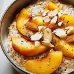 Bowl of creamy Peach Almond Chia Oats topped with fresh peaches and almonds