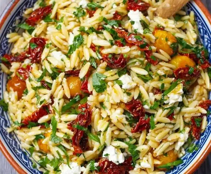 Orzo pasta salad with sun-dried tomatoes and feta cheese, fresh and colorful dish