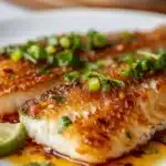 Delicious pan fried fish served with herbs and lemon slices