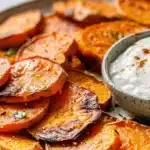 Roasted sweet potato rounds served with yogurt dip on a plate