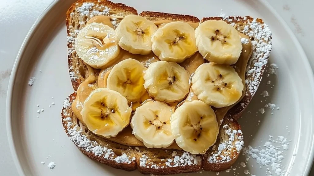 Creamy peanut butter banana toast topped with slices of banana.