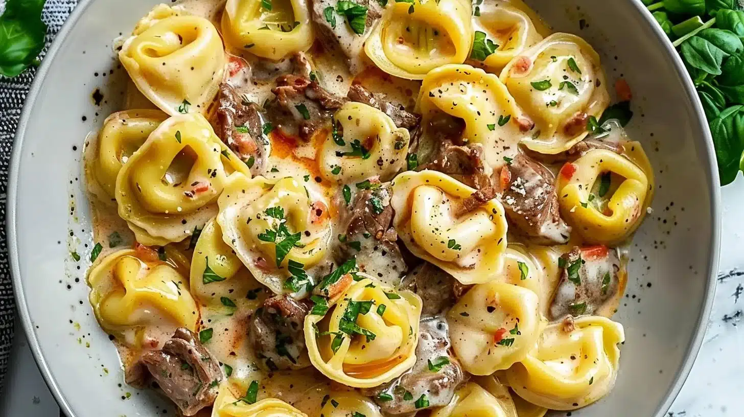 Delicious Cheese Steak Tortellini Pasta dish garnished with herbs
