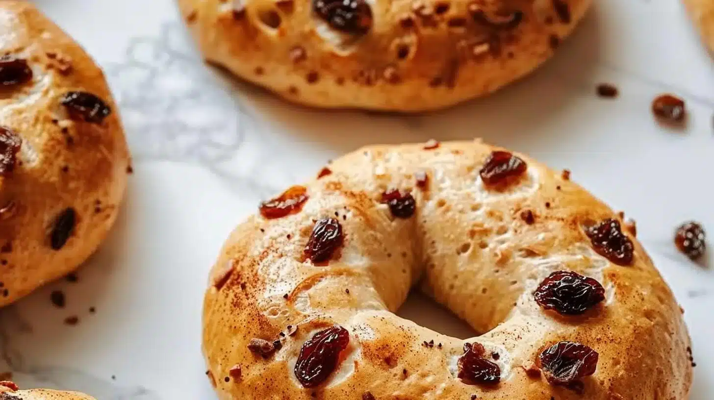 Freshly baked cinnamon raisin Greek yogurt bagels on a wooden table