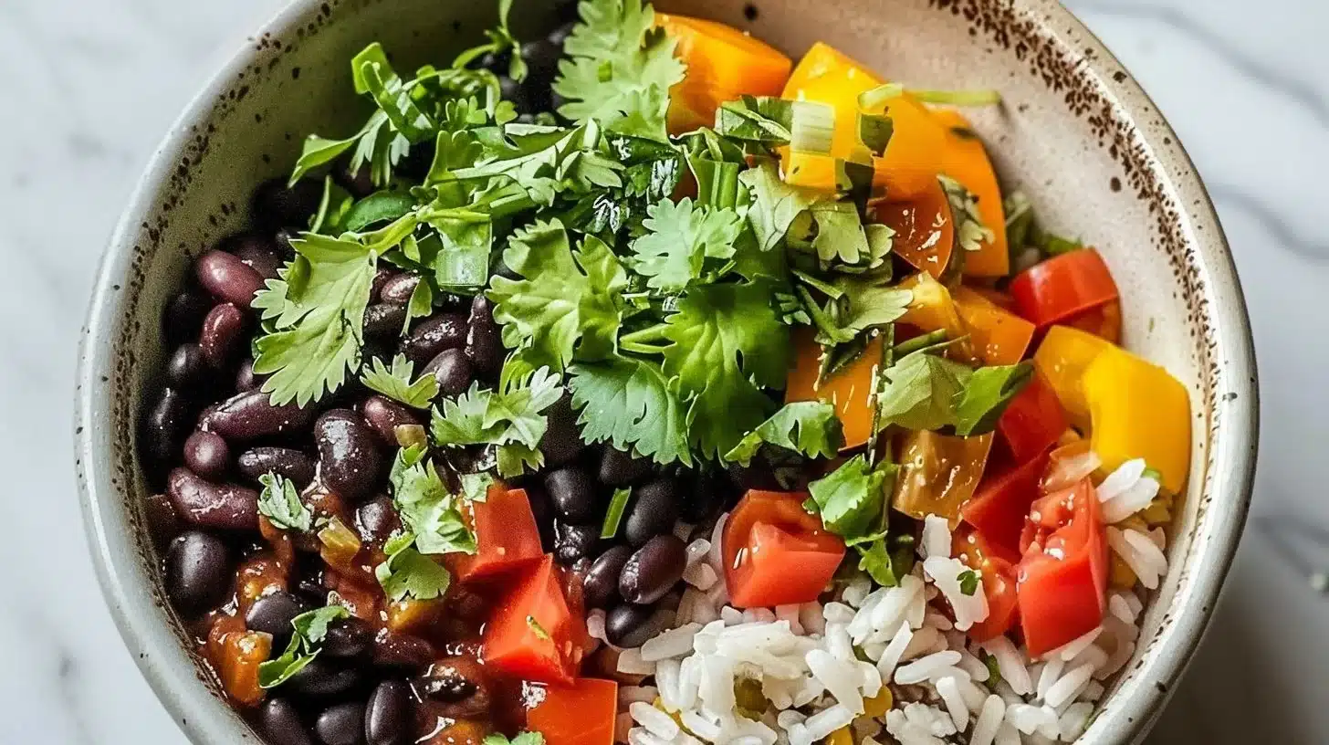 Delicious and colorful black bean rice bowl topped with fresh ingredients